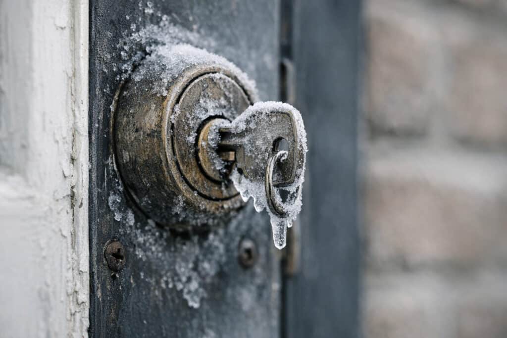 Bevroren deurslot met ijskristallen in het sleutelgat