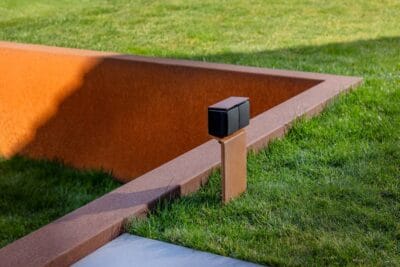 Moderne tuin met zwart stopcontact en cortenstaal paaltje van Niko
