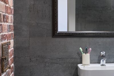 Industriele badkamer met betonlook en baksteenaccent