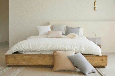 Minimalistische slaapkamer met houten bed en kussens