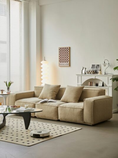 Minimalistische woonkamer met textielbank en inbouwkasten