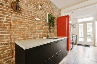 Moderne keuken met bakstenen wand en zwarte meubels