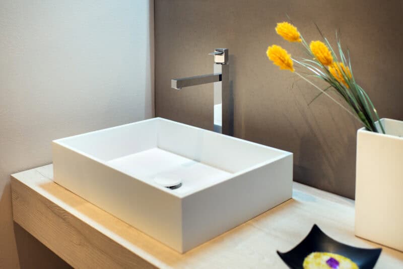 Moderne badkamer met witte opbouwlavabo en kranen