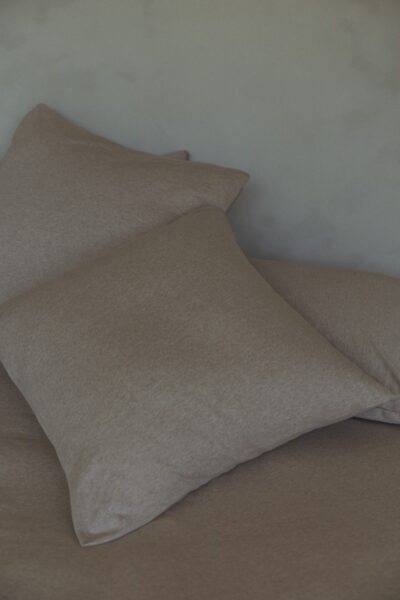 Zachte bruin jersey bedlinnen in minimalistische slaapkamer