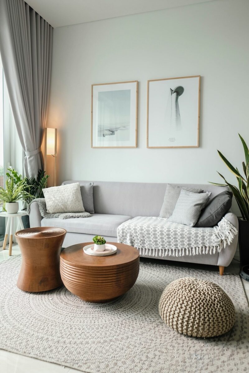 Minimalistische woonkamer met grijze bank en houten meubels