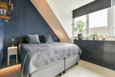Moderne slaapkamer met blauwe schuine wand