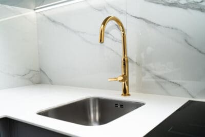 Moderne keuken met gouden keukenkraan en spoelbak