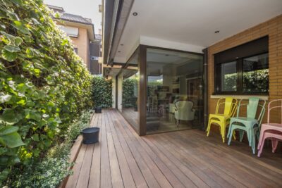 Modern terras met hardhouten vloer en kleurige stoelen