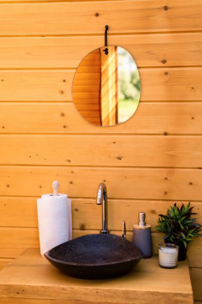 Rustiek toilet met houten wand en handwasbak