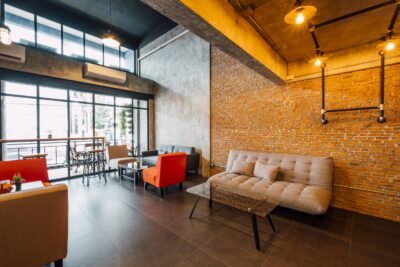 Industriele woonkamer met grote ramen en bakstenen muur