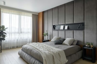 Moderne slaapkamer met grijs hoofdbord en zachte textiel