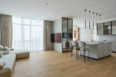 Moderne woonkamer met grote ramen en lichte afwerking