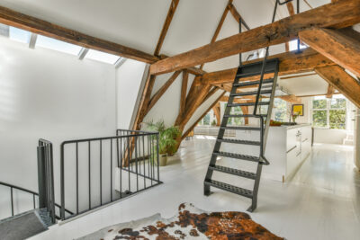 Moderne zolder met stalen trap en houten balken