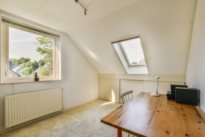 Minimalistische zolder met dakraam en houten tafel